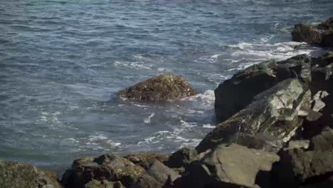 olas golpeando las rocas de la playa