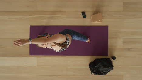 overhead view flexible yoga woman practicing reverse warrior pose enjoying healthy lifestyle exercising in fitness studio training on exercise mat