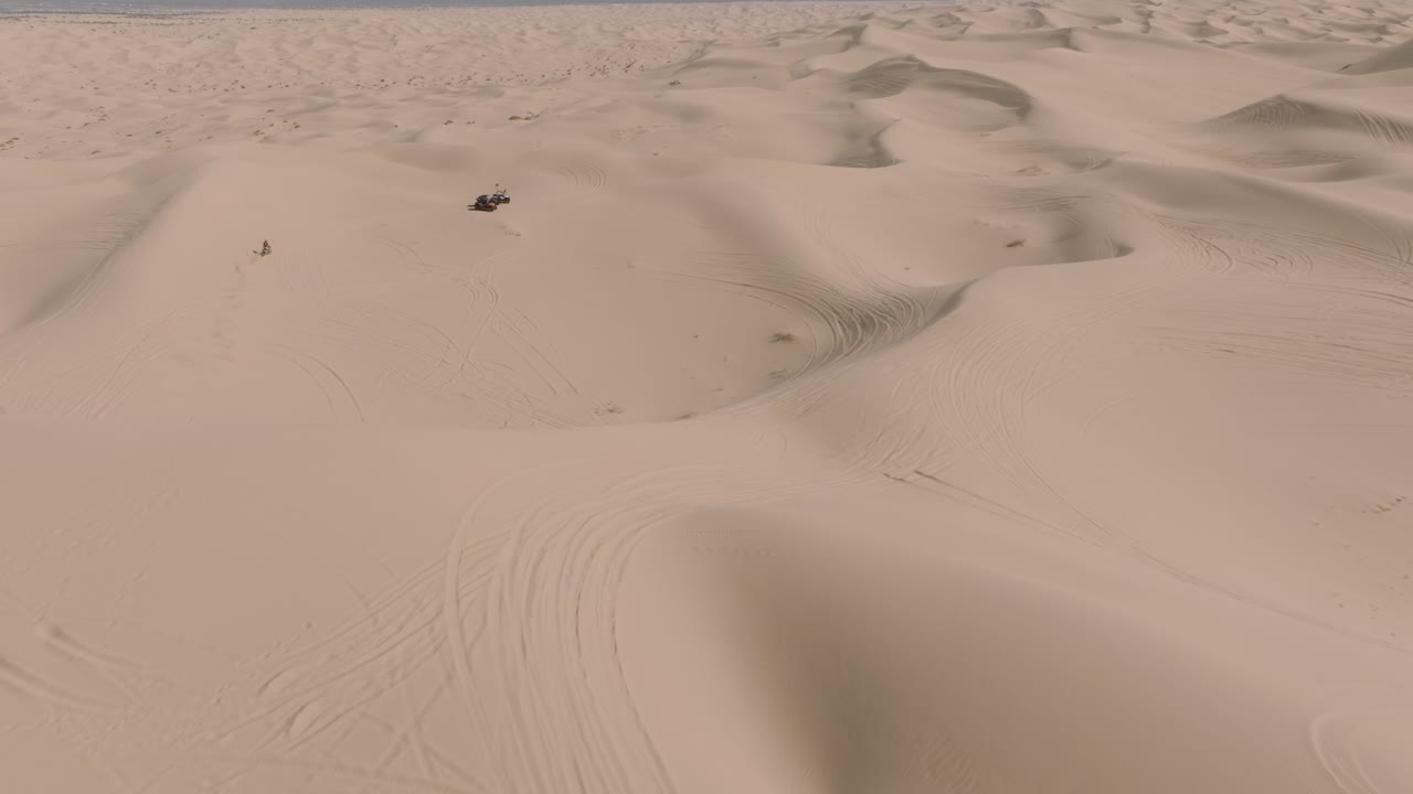 motociclistas todoterreno en el paisaje de dunas de arena en glamis, california, visto por un dron