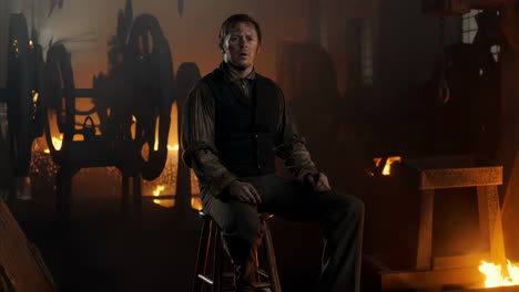 man in vest sitting in factory