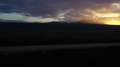 a drone fly's towards the lake dam and rises up to a beautiful sunrise