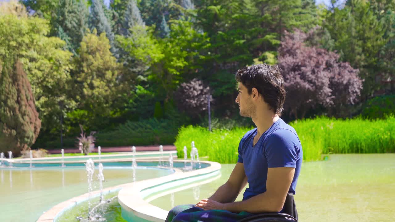 ⁇ 체어를 타고 야외에 앉아 있는 젊은 장애인