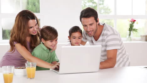 family using a white laptop