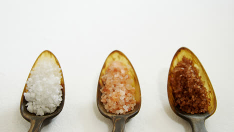 various types of sea salt in a spoon 4k