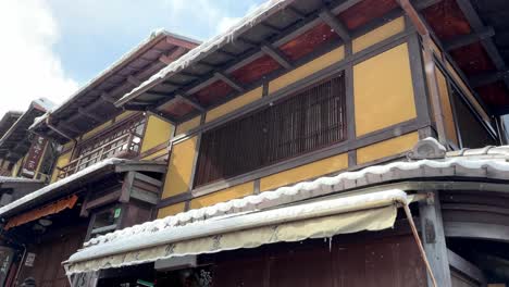 Serene-Winter-Scene-with-Japanese-Building-and-Soft-Snowing-with-Blue-Sky