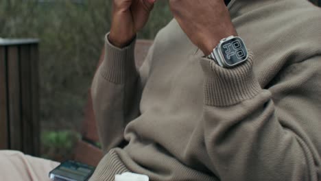 man adjusting earbuds and smartwatch outdoors