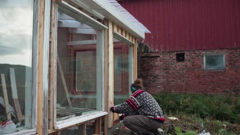 Un-Hombre-Está-Construyendo-El-Marco-De-La-Ventana-De-Cristal-Del-Invernadero