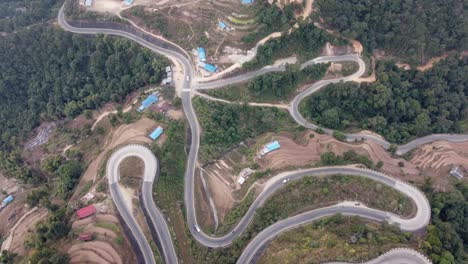 Vista-Aérea-Hacia-Abajo-Del-Tráfico-En-La-Autopista-Bp,-Autopista-Bardibas,-Que-Muestra-Las-Curvas-Y-Los-Giros-A-Medida-Que-Serpentea-A-Través-De-Las-Colinas-De-Nepal