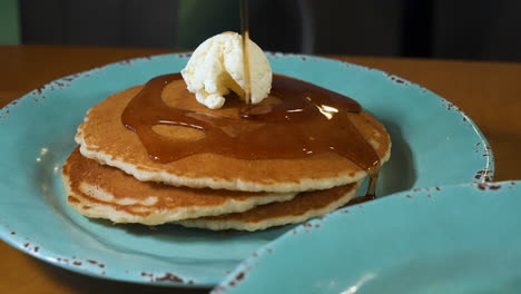 drizzling warm maple syrup over buttered stack of fluffy buttermilk pancakes, slow motion slider 4k