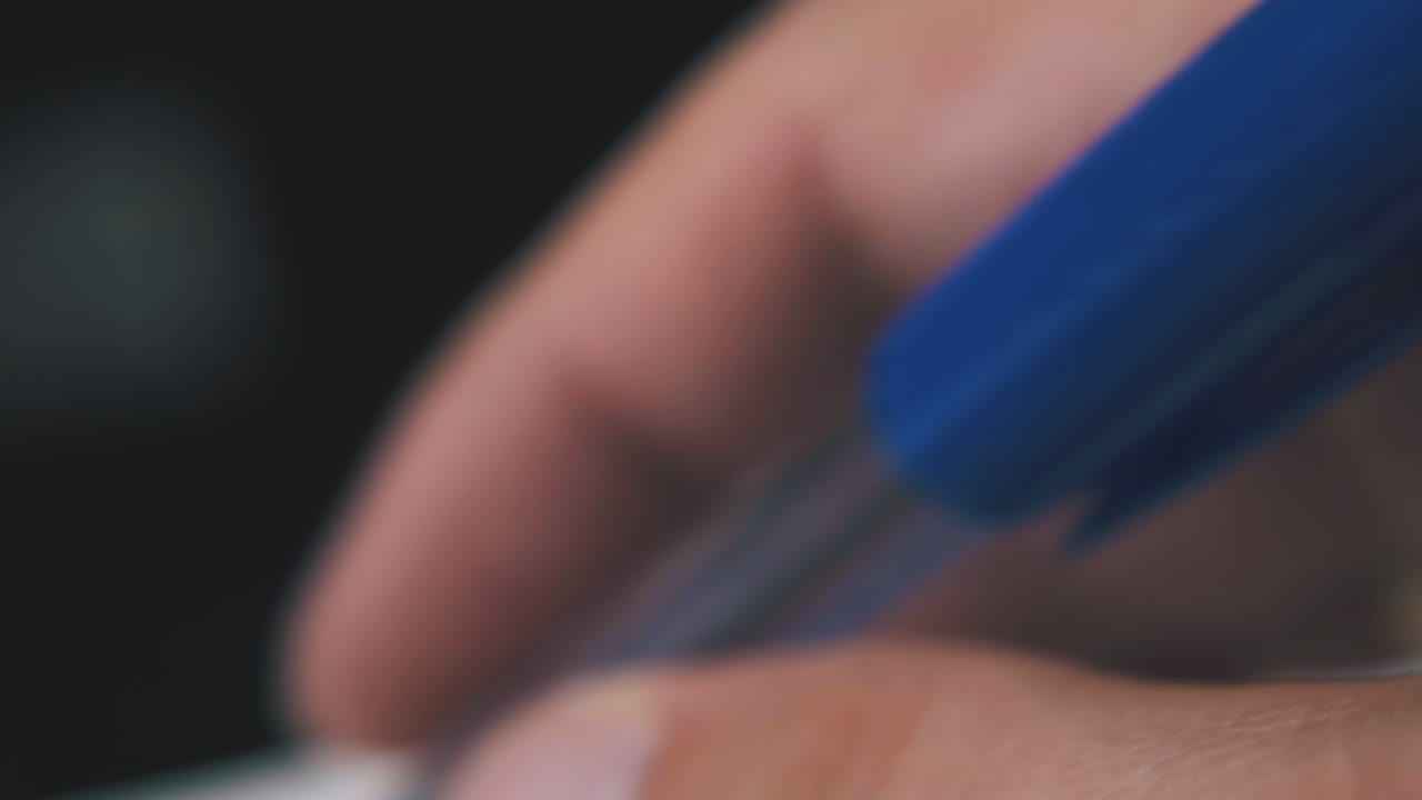 남자가 불분명한 배경에 투명한 케이스에서 펜으로 놀고 있습니다.