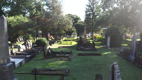 drone flying closely between gravestones and tombs in a cemetery on a sunny day in australia