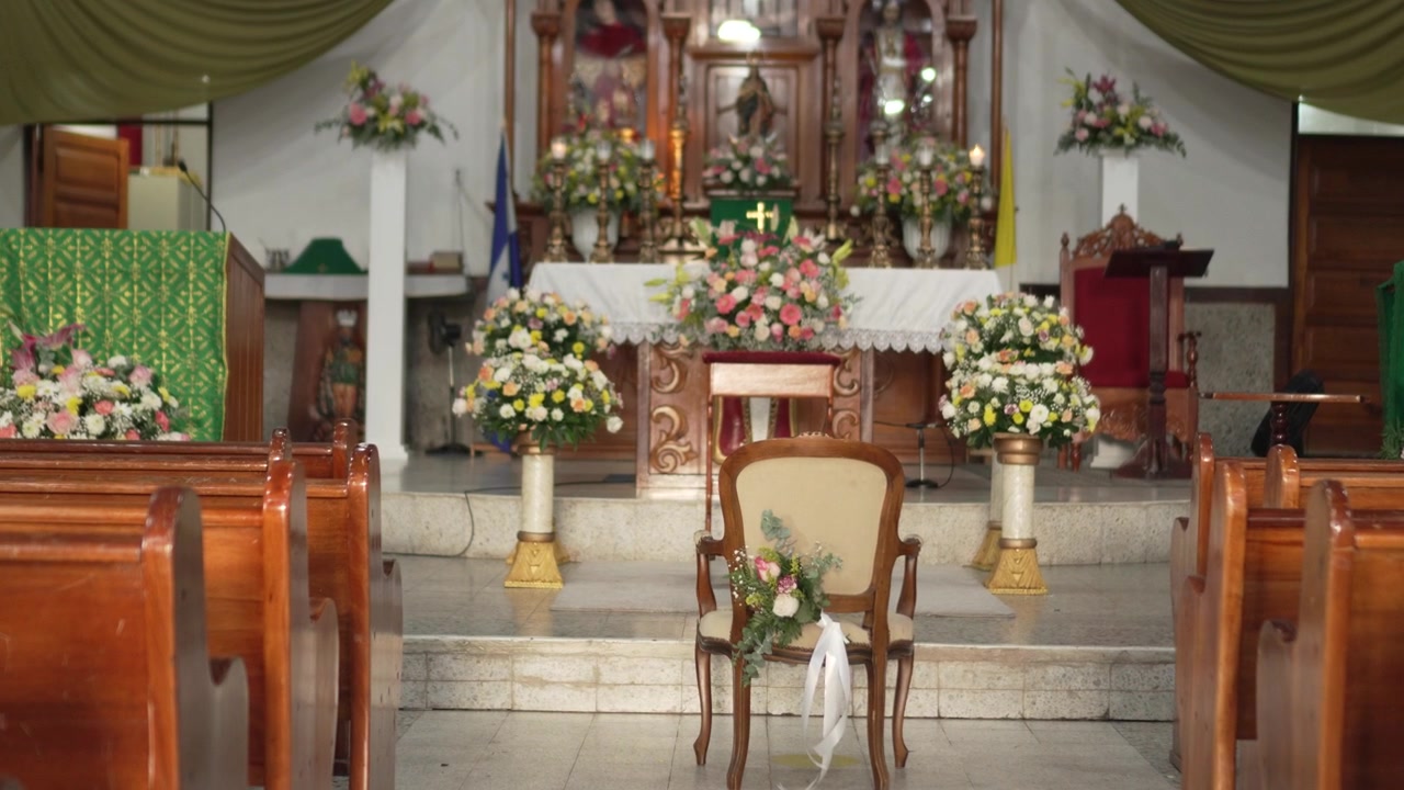 Igreja Católica tradicional latino-americana com grande altar de madeira e arranjos florais. Honduras