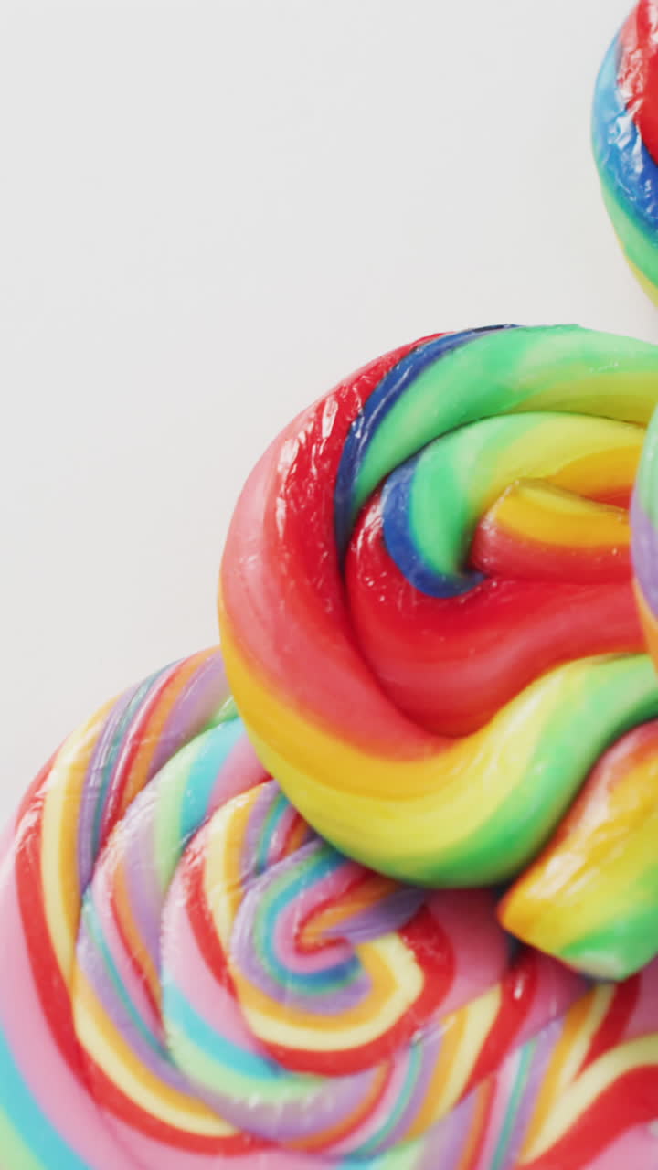 vídeo de filas de piruletas multicolores sobre un fondo blanco
