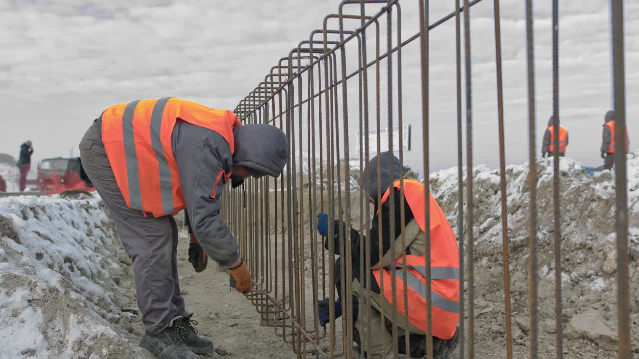 Construction Workers Laying Rebar in Winter Conditions
