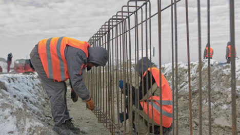 construction workers laying rebar in winter conditions