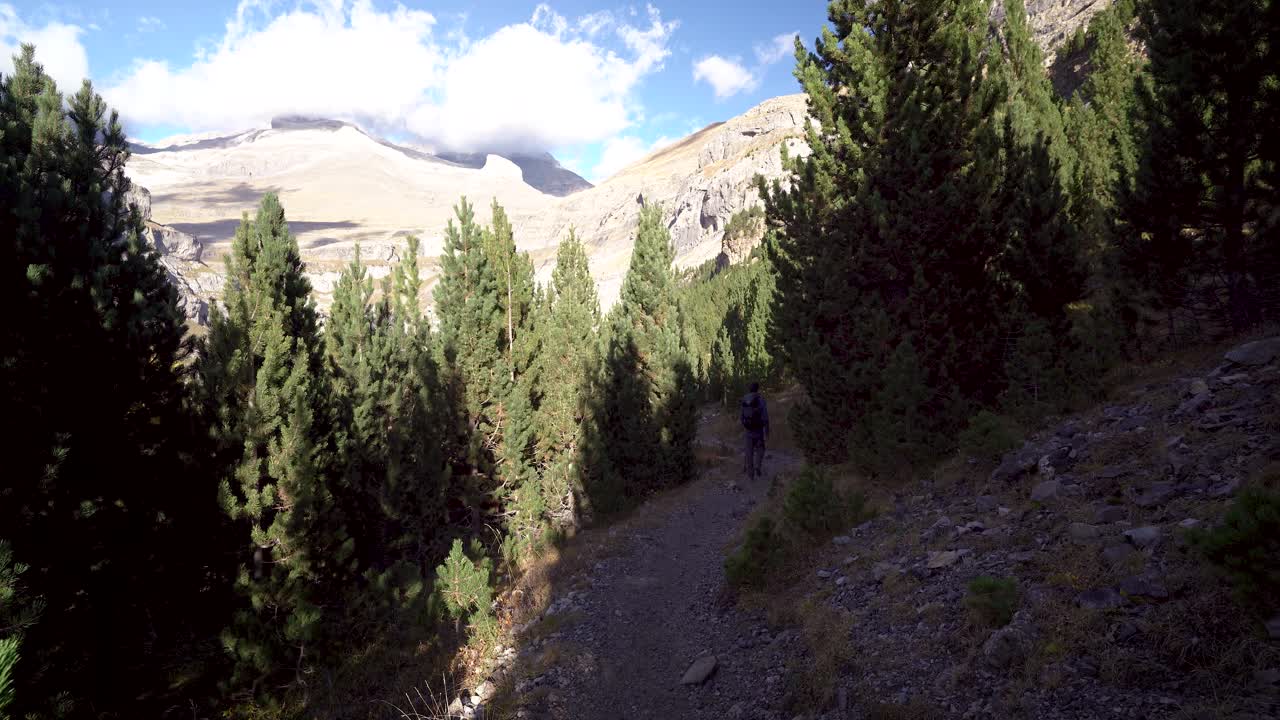 back view of youn european hiker with big backpack hiking in Ordesa National Park, huesca, Spain