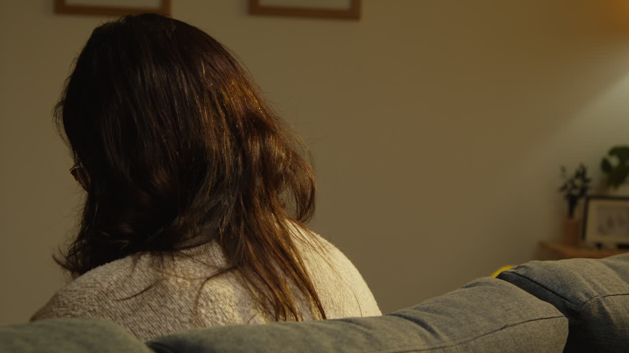 혼자 소파에 앉아있는 외롭고 불행한 젊은 여성의 뒷모습 정신 건강 문제 2