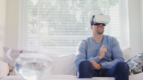 joven sentado en el sofá experimentando un auricular de realidad virtual 4k 4k