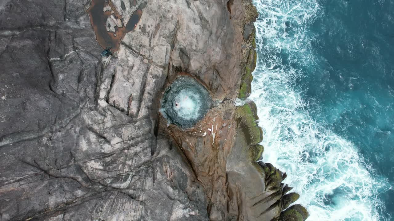 A man jumps into a rock pool