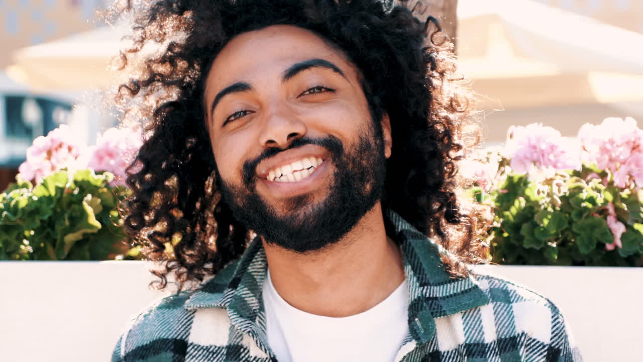 Homem feliz com cabelo cacheado e óculos de sol