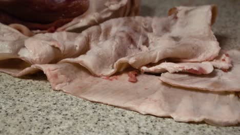 closeup on a pork separation process on a kitchen table in slow motion tilt up