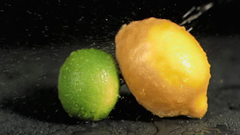 agua rociada sobre una lima y un limón en súper cámara lenta