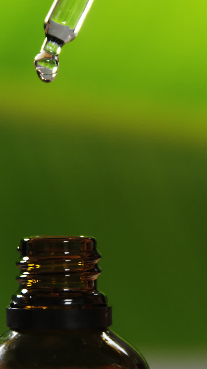 gotero que vierte una gota de líquido en una botella