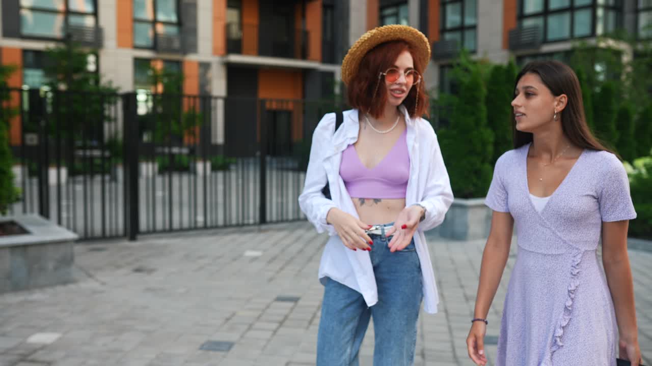 dos mujeres jóvenes caminando y hablando en la calle de la ciudad