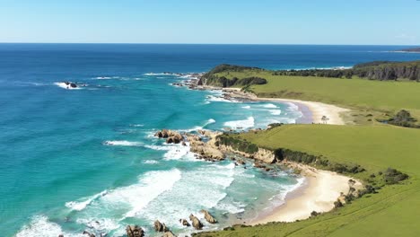 Una-Excelente-Toma-Aérea-De-Las-Olas-Rompiendo-Las-Costas-De-La-Playa-De-Narooma-En-Nueva-Gales-Del-Sur,-Australia