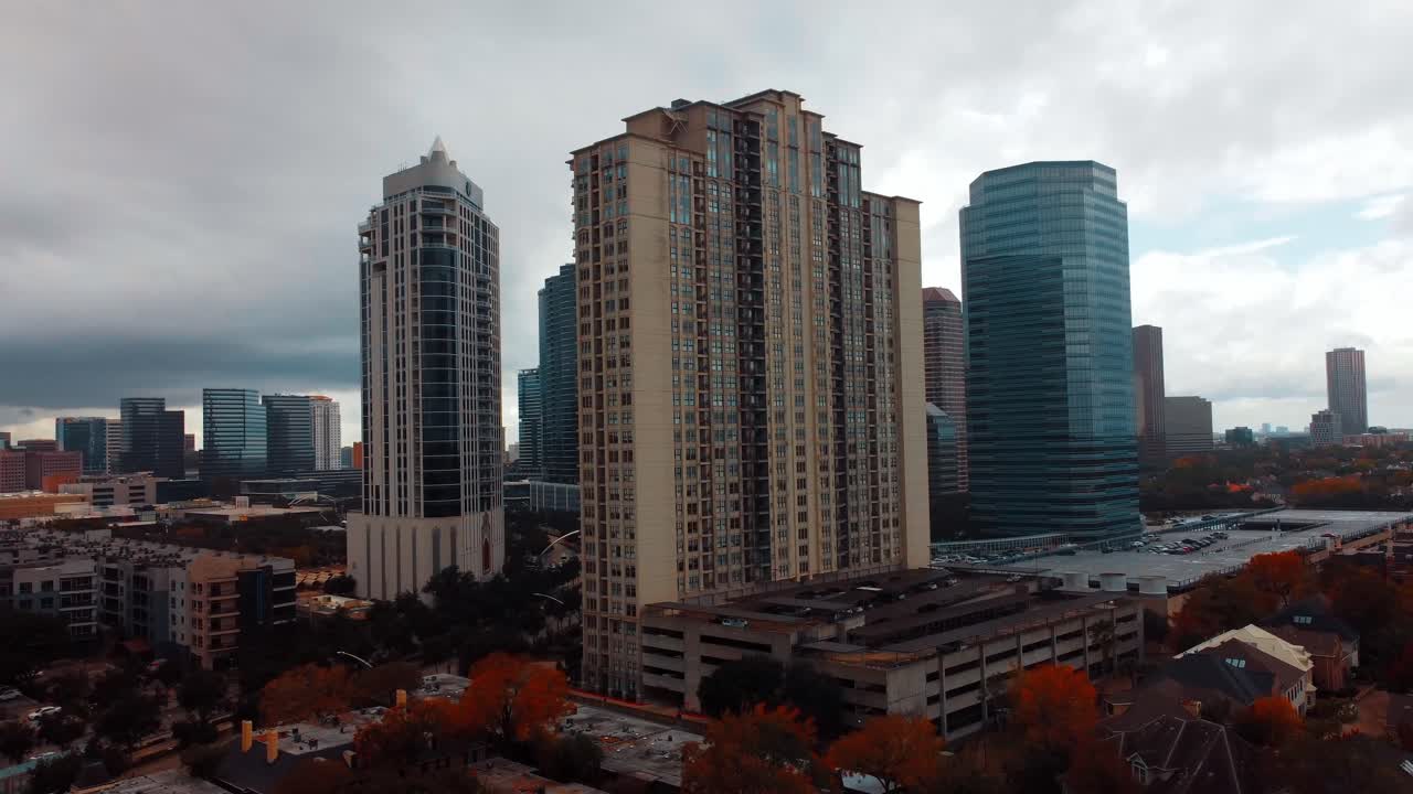 A flying over aerial view of a high-rise apartment complex, located downtown