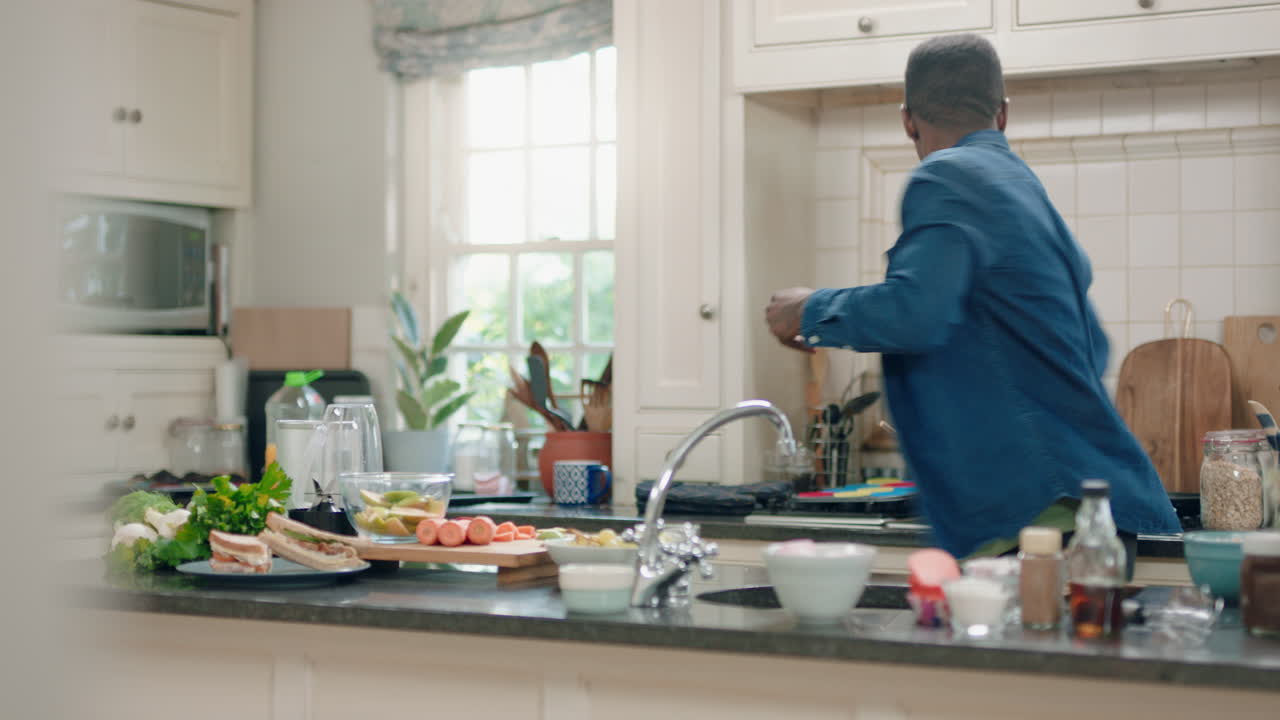 uomo afroamericano felice che balla in cucina che si diverte a ballare celebrazione che si gode il fine settimana a casa