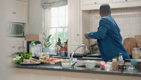 happy african american man dancing in kitchen having fun dance celebration enjoying weekend at home