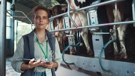 agriculture worker posing dairy facility portrait. automatic milking process.