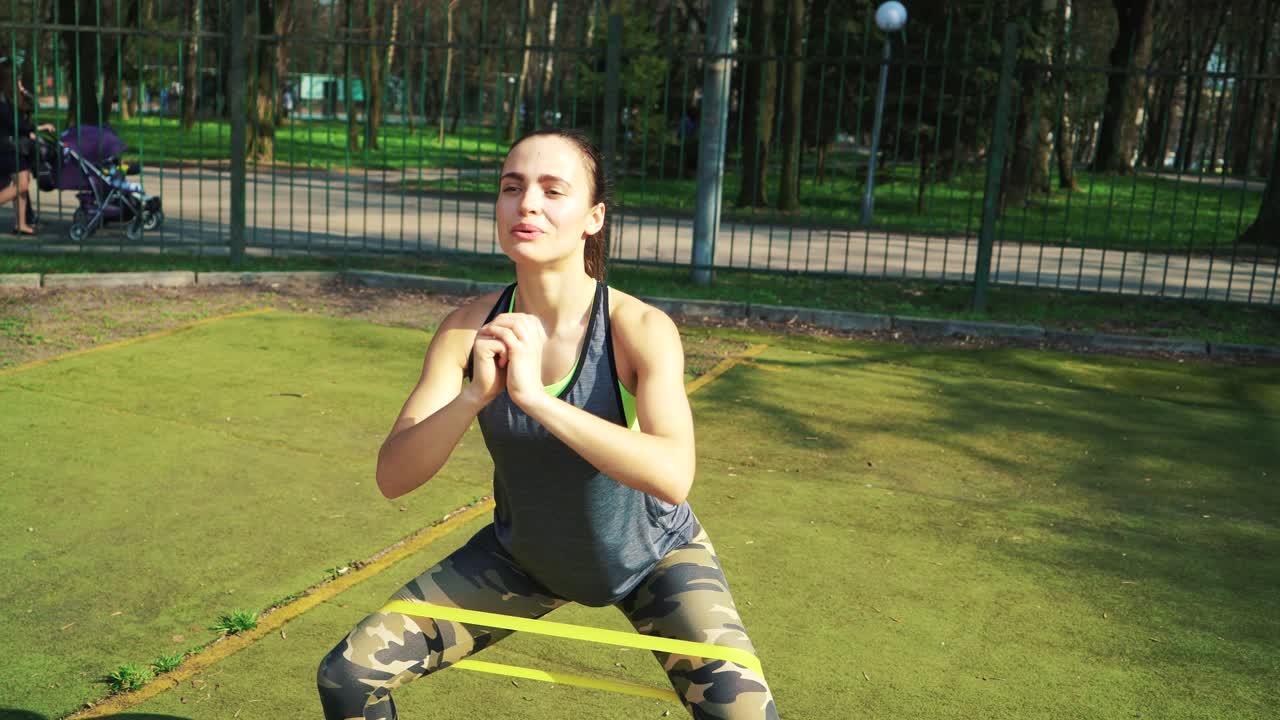 Sporty woman doing stretching exercises outdoor. Fitness girl doing lunges in park at summer. Workout at sunny day.