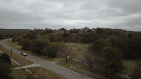 Road-in-the-countryside-surroundedby-trees-with-houses-in-the-background