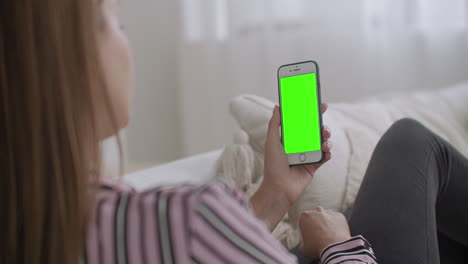 young-woman-is-streaming-in-social-net-by-smartphone-with-green-screen-for-chroma-key-technology-chatting-by-internet