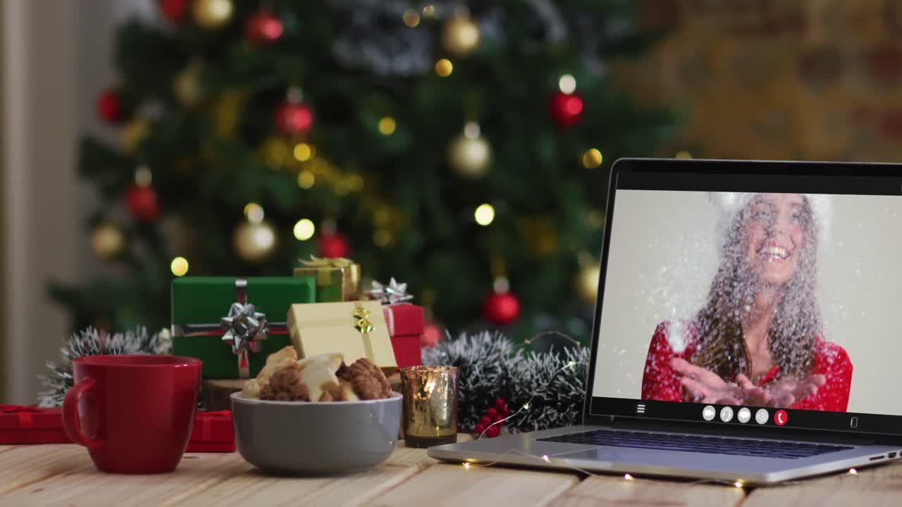 feliz mujer caucásica en disfraz de santa en videollamada en computadora portátil, con decoraciones de navidad y árbol