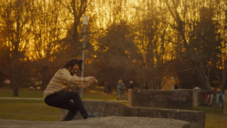 man jumping in park at sunset