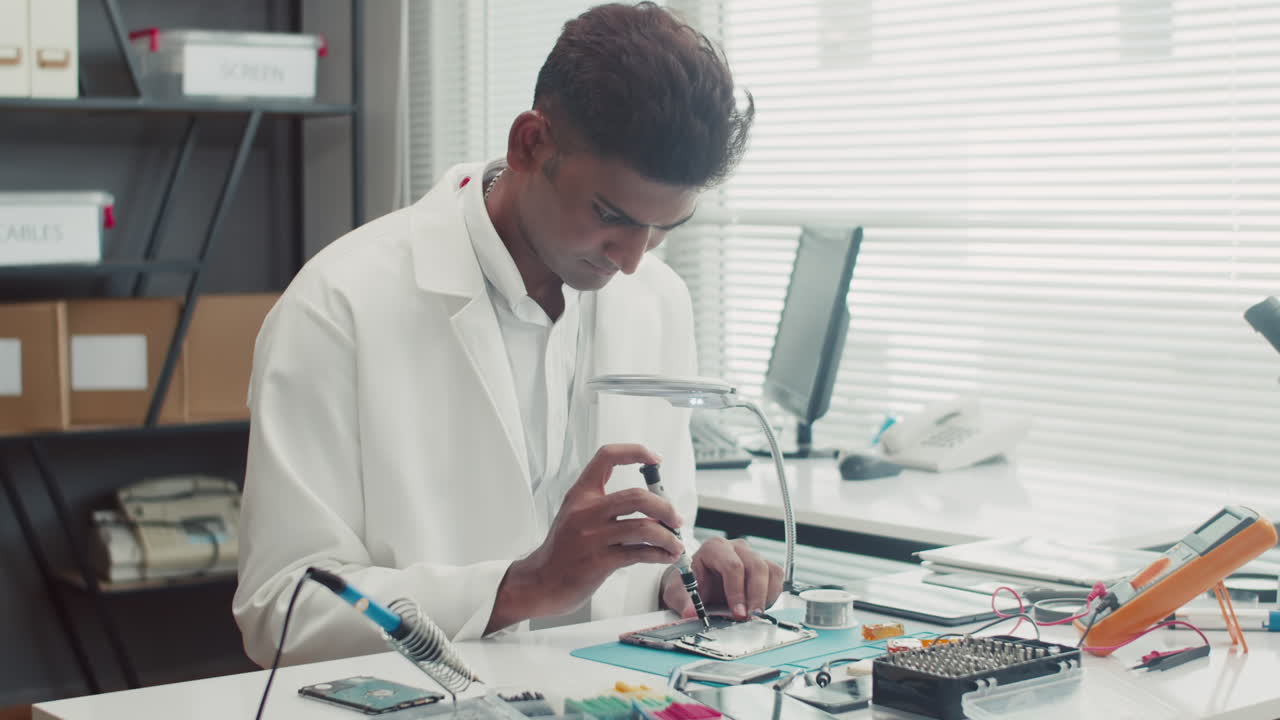 Repair Specialist Examining Phones Battery at Service Center
