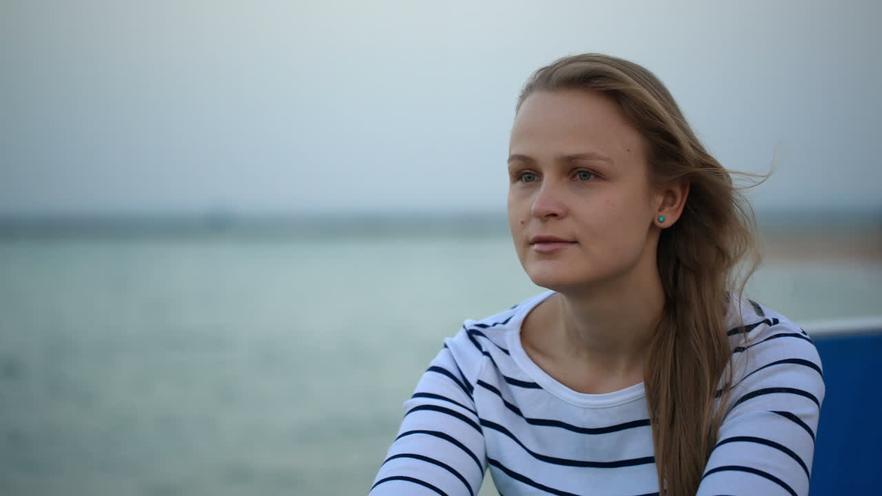 Zamyšlená žena u moře.