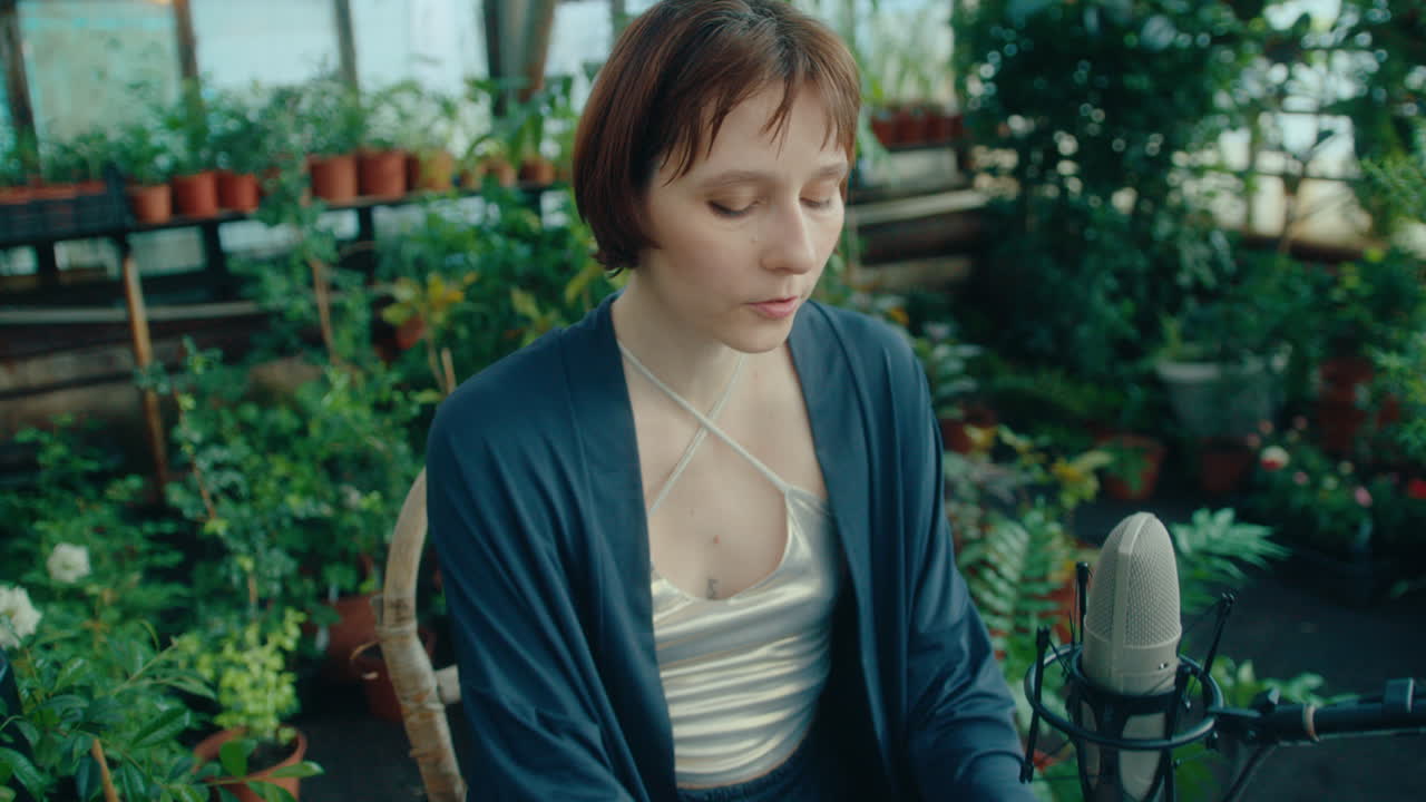 Female Singer Playing Keyboard during Solo Performance in Greenhouse