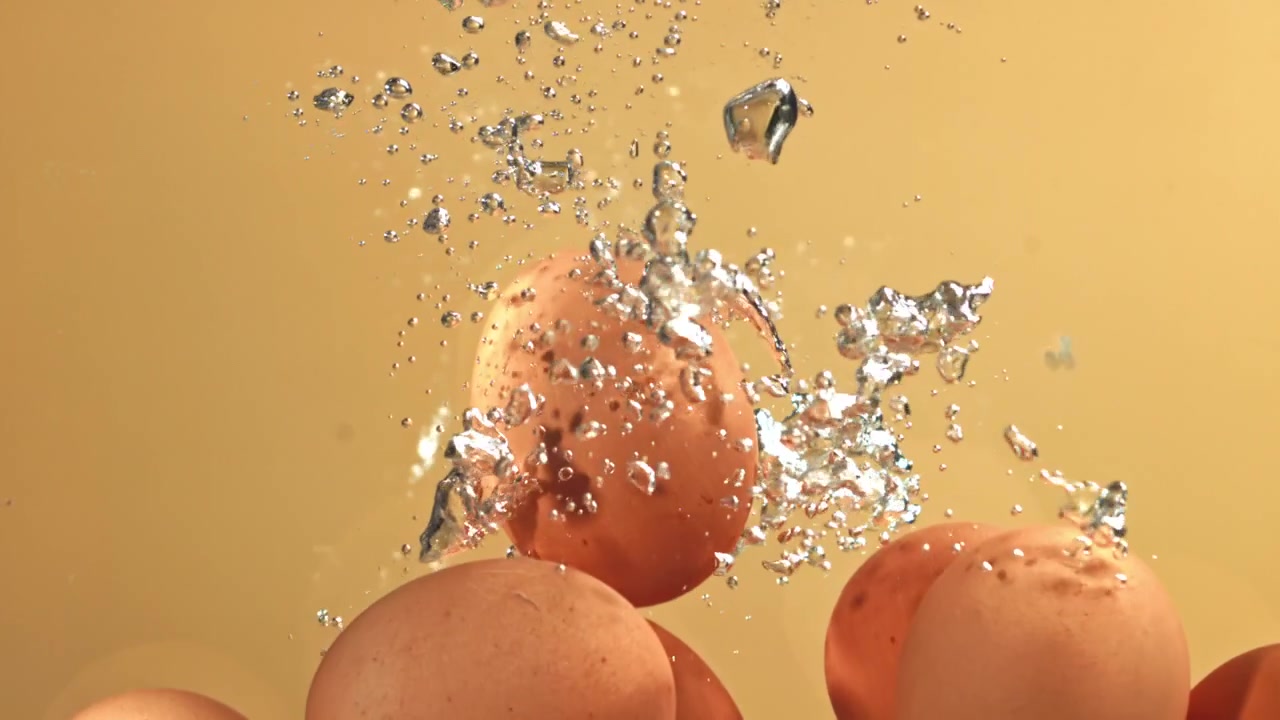 Brown Eggs Falling into Water with Bubbles on Yellow Background