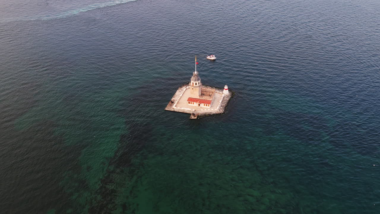 Clear waters surround the Maiden’s Tower as a boat passes, capturing the peaceful essence of this legendary islet