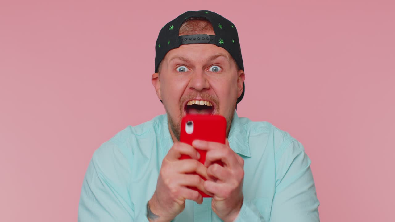 Hombre feliz emocionado usar teléfono móvil decir wow sí descubrió grandes noticias de gran victoria haciendo gesto ganador