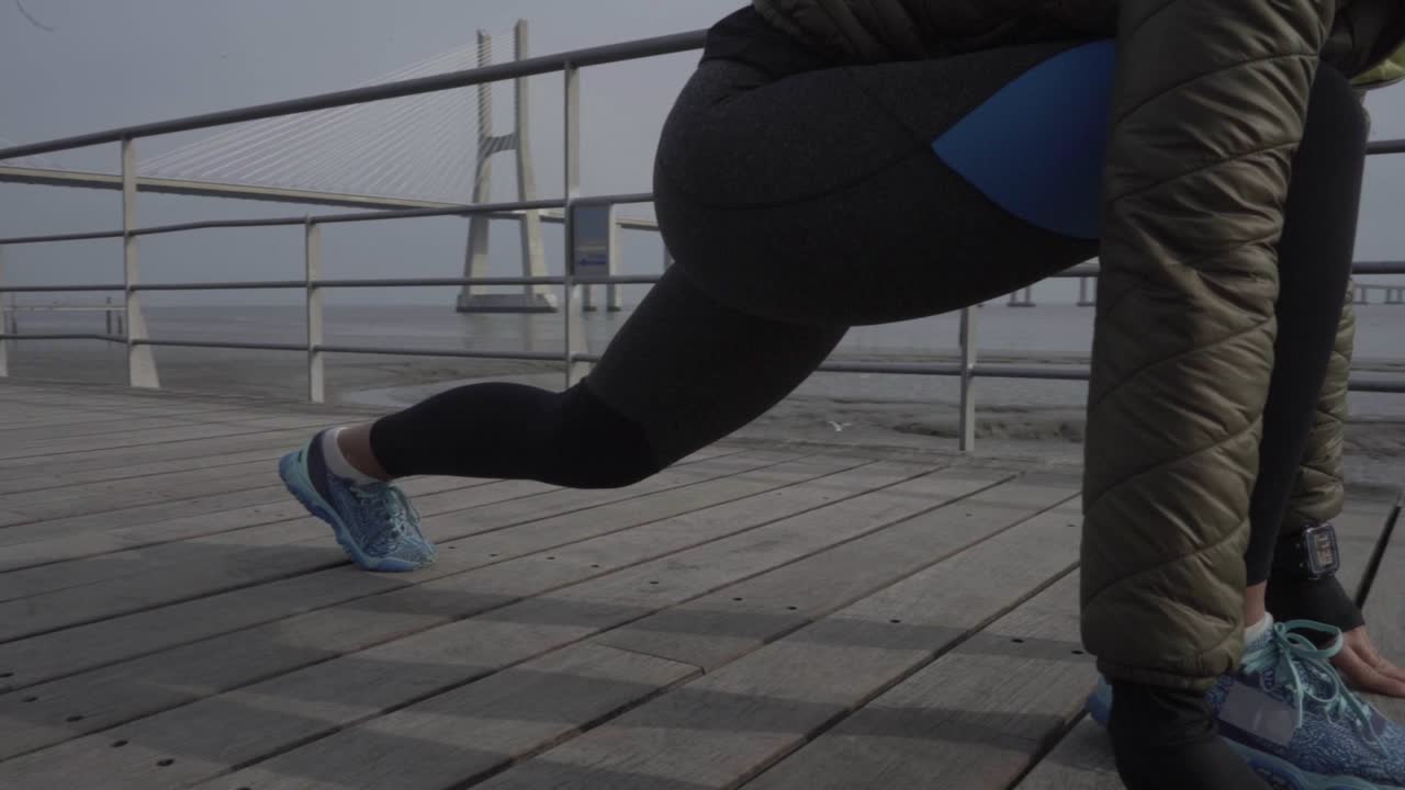 스포츠 의류 와 스포츠 시계 를 입고 달릴 준비 를 하고 있는 젊은 여자 의 절단 된 사진