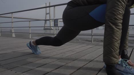 foto recortada de una mujer joven vestida con ropa deportiva y reloj deportivo preparándose para correr
