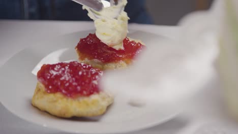 foto de cerca de una persona con el tradicional té de la tarde británico con crema de bollos y mermelada 2