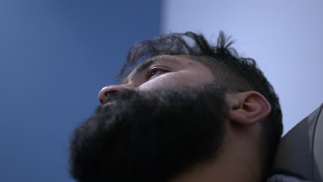 la cabeza del hombre tumbado en un sofá mirando al techo moviendo los ojos por la depresión.