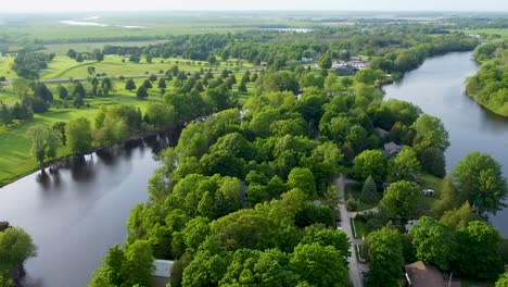 Drone-circling-over-a-Collingwood-neighborhood-surrounded-by-a-lake-on-a-sunny-summer-day