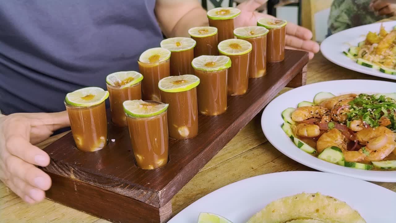 Shrimp and seafood buffet served on wooden table during meeting, juice shrimp shots in foreground